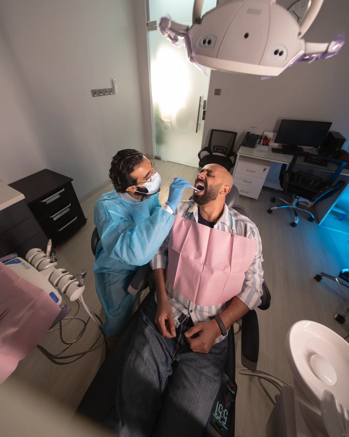 Fahad in the dentist's chair mid-check-up, shot from above, FLOOSS campaign still