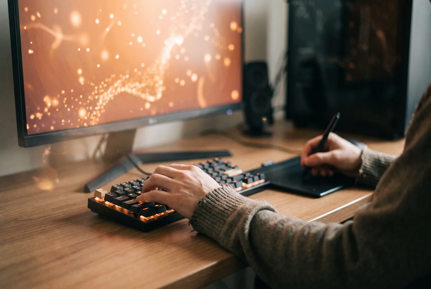 A creative editor's hands at a keyboard with abstract warm light suggesting AI